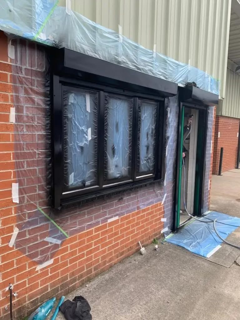 Commercial window frames masked and painted dark grey